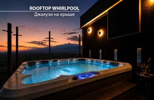a jacuzzi tub with a sunset in the background at Miramare Magnetic Beach Hotel in Kobuleti