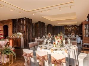 a banquet hall with white tables and chairs with bows at Hotel Des Arts Saigon Mgallery Collection in Ho Chi Minh City +202 photos
