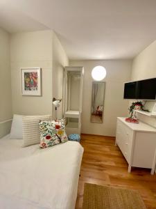 a bedroom with a white bed and a white dresser at Apartments Olga in Bled