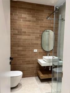 a bathroom with a toilet and a sink and a mirror at Piknik Suites in Dhërmi