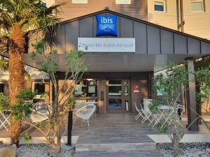 a restaurant with chairs and tables in front of a building at Hotel Ibis Budget Deauville in Deauville +15 photos