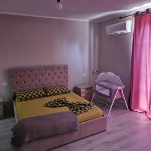a bedroom with a bed and a pink curtain at Villa Doku in Valjiosi