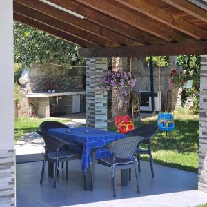 a blue table and chairs under a pergola at Villa Doku in Valjiosi