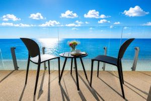 a table and chairs on a balcony with the ocean at Miramare Magnetic Beach Hotel in Kobuleti