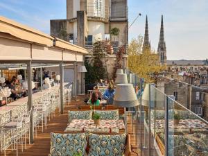 a balcony with tables and chairs on a building at Mama Shelter Bordeaux Centre in Bordeaux