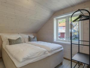 a bed in a room with a window at Arctic Nest in Nyksund