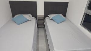 two beds sitting next to each other in a room at Espectacular casa, piscina privada- Ricaurte in Ricaurte +16 photos