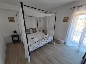 a bedroom with a canopy bed and a wooden floor at Gredò Home & SPA in Gratteri