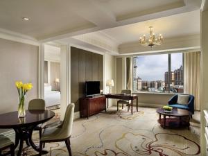 a living room with a room with a bed and a desk at Sofitel Xining in Xining
