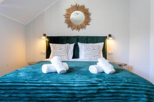 a bedroom with a blue bed with white pillows and a mirror at Apartamenty Lagos in Karwia