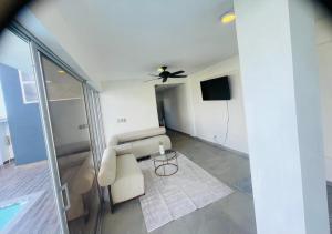 a living room with a couch and a ceiling fan at Villa renacer in Baní