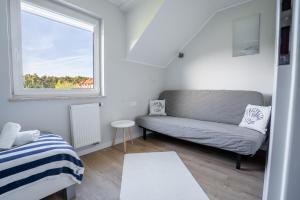 a living room with a couch and a window at Apartamenty Lagos in Karwia