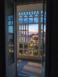 an open window with a view of a city at O Lar do Rodrigo in Castro Caldelas
