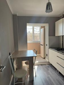 a kitchen with a table and chairs and a refrigerator at Apartments Aibergenova 4 in Shymkent
