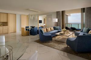 a living room with blue couches and a table at The St. Regis Bal Harbour Resort in Miami Beach