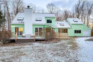 a green house with a porch in the snow at Green Mountain Getaway in Jamaica