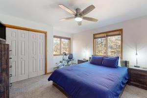a bedroom with a blue bed and a ceiling fan at Green Mountain Getaway in Jamaica