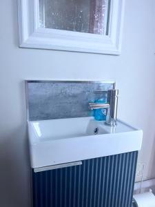 a bathroom sink with a mirror above a radiator at Bluebell Tent at Ballyward Croft in Ardkeen