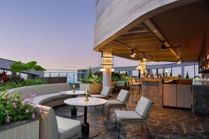 an outdoor patio with tables and chairs and a bar at Sheraton Vinh in Yên Thinh (1)