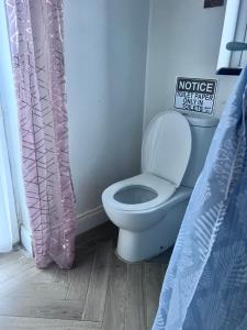 a bathroom with a toilet and a sign on the wall at Bluebell Tent at Ballyward Croft in Ardkeen +34 photos