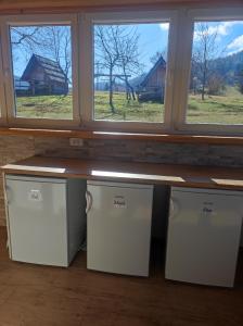 a counter in a room with three windows at Village Vista in Rob