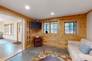 a living room with wooden walls and a white couch at Meet Me At Our Spot in Moretown