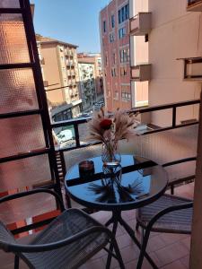 a vase with flowers on a table on a balcony at Angy's House in Verona
