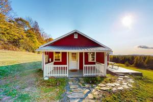 a red and white house on a grass field at Whispering Pines Retreat in Barton