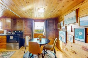 a kitchen with a table and chairs in a cabin at Whispering Pines Retreat in Barton