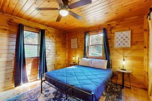 a bedroom with a bed in a log cabin at Whispering Pines Retreat in Barton