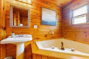 a bathroom with a sink and a bath tub at Whispering Pines Retreat in Barton +68 photos