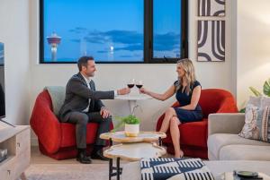 a man and woman sitting at a table with glasses of wine at Nuage 2 Bed 2 Bath 2 Balconies Parking in Calgary