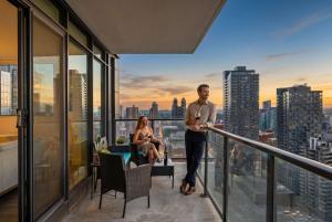 a man standing on the balcony of a building at Nuage 2 Bed 2 Bath 2 Balconies Parking in Calgary