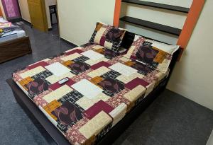 a bed in a room with a quilt on it at Fantasy Homestay in Thiruchendur