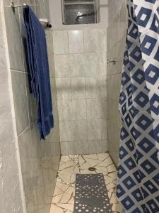 a bathroom with a shower with a blue shower curtain at 399 Place in Umtali +23 photos