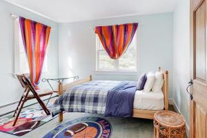 a bedroom with a bed and two windows at Sweet Berry Farm in Jamaica