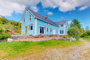 a blue house with a large yard at Sweet Berry Farm in Jamaica