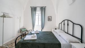 a bedroom with a large bed with towels on it at Casa Superga by Rentbeat in Cisternino