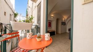 a small orange table on a balcony with a plant at Casa Superga by Rentbeat in Cisternino