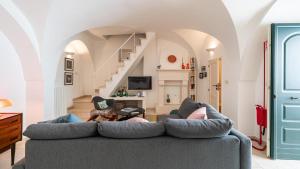 a living room with a couch and a staircase at Casa Superga by Rentbeat in Cisternino