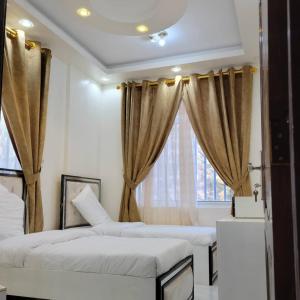 a bedroom with two beds and a window at ألعز in Qaḩāzah