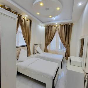 two beds in a room with windows at ألعز in Qaḩāzah