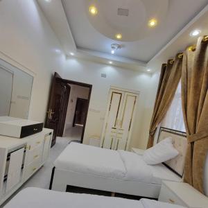 a bedroom with two beds and a large mirror at ألعز in Qaḩāzah