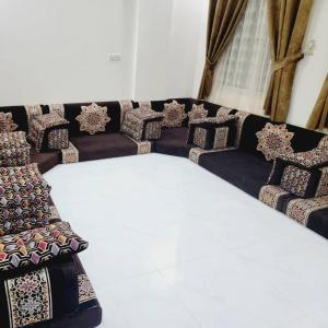 a long couch with pillows on it in a room at ألعز in Qaḩāzah +2 photos