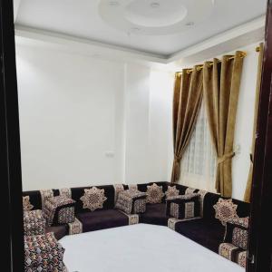 a living room with a couch and curtains at ألعز in Qaḩāzah