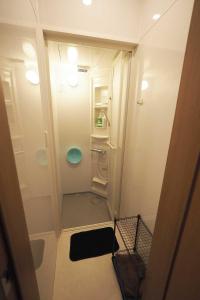 a small bathroom with a walk in shower at ライダーハウスみかさんち in Marugame