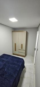 a bedroom with a bed and cabinets in it at RG Kitnet02 in Curitiba