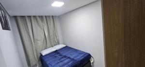 a small room with a bed and a window at RG Kitnet02 in Curitiba