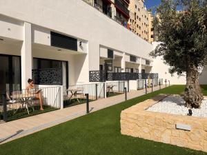 a woman sitting at a table in front of a building at Maritime Coliving Valencia in Valencia