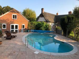 a swimming pool in the yard of a house at Brook Lodge, One bed house in AONB Dorset with swimming pool in Iwerne Minster
